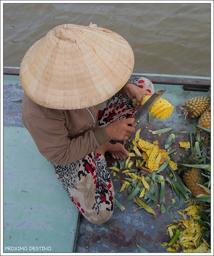 Vendedora de piña en el mercado flotante de Cai Rang